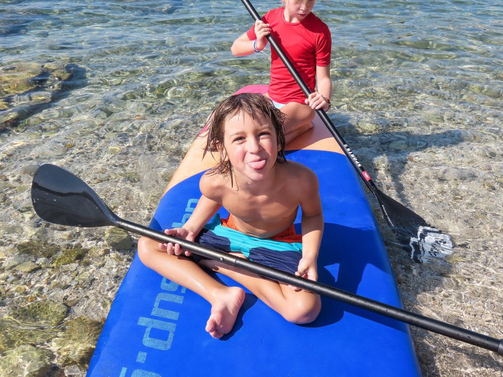 kids sitting on paddle board scaled